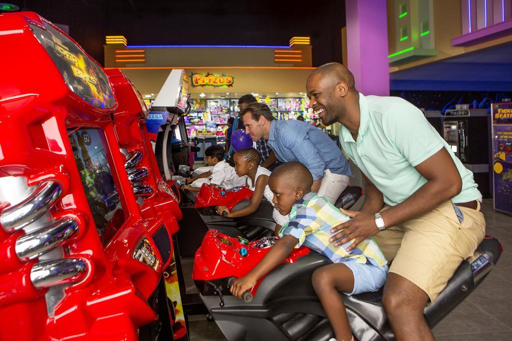 The Palace Of The Lost City At Sun City Resort Экстерьер фото A father and son playing a racing game at a Dave & Buster's